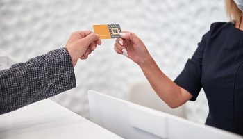 Cropped copy-space photo of a blank plastic card being given to a shop customer by a staff member